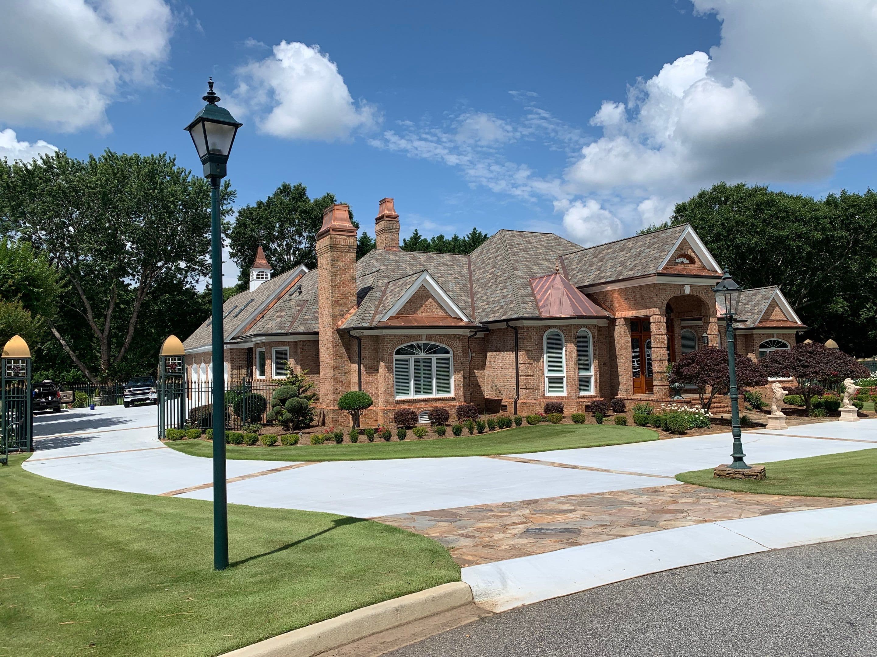 Brick home with a multitone shingle roof and copper roof accents