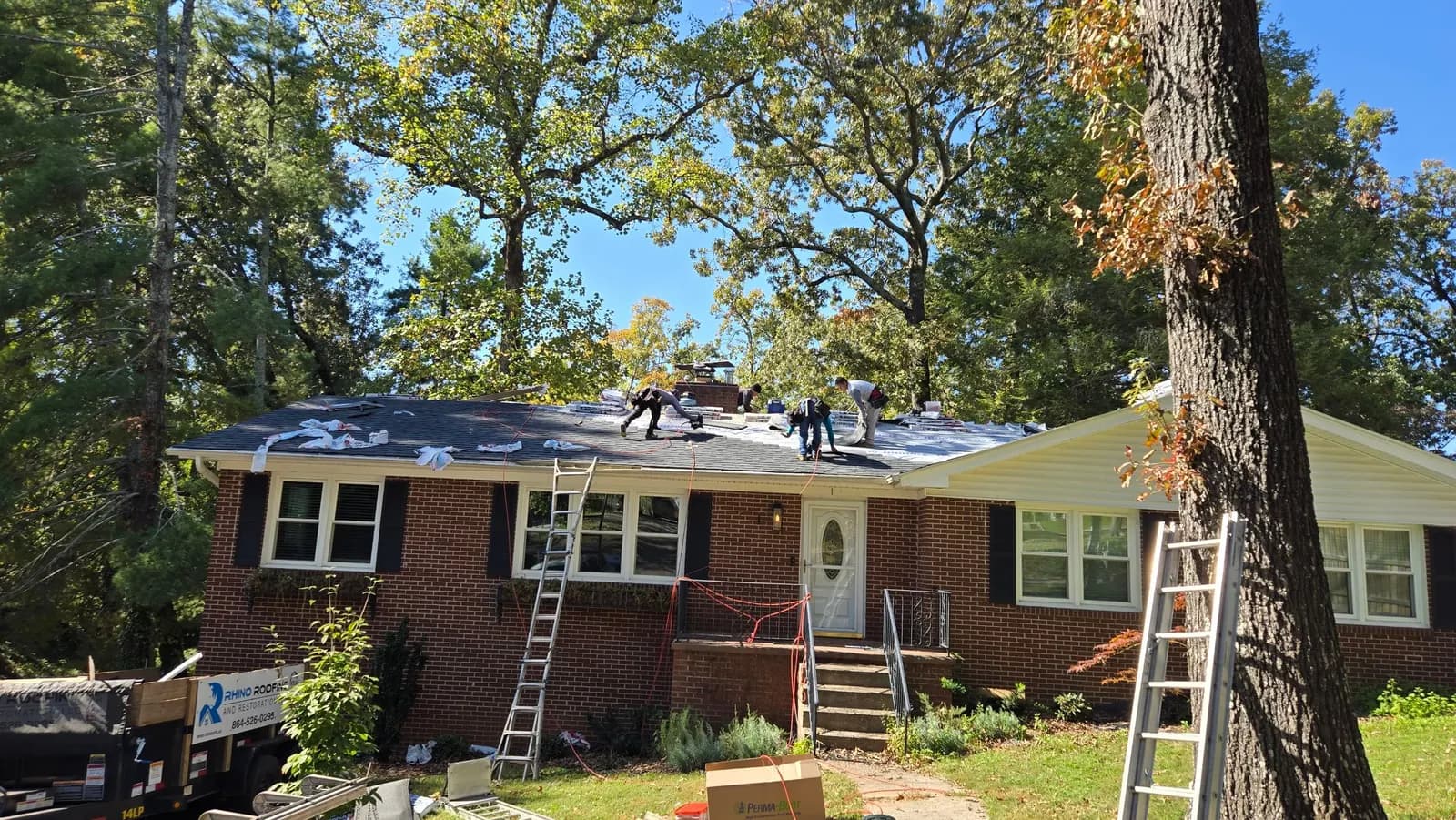 Roof replacement underway on a brick ranch home